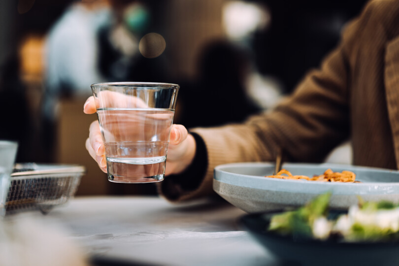 Close-up-of-young-Asian-woman-drinking-a-glass-of-water-while-having-meal-in-a-restaurant.-Healthy-lifestyle-and-stay-hydrated_Gettyimagesd3sign