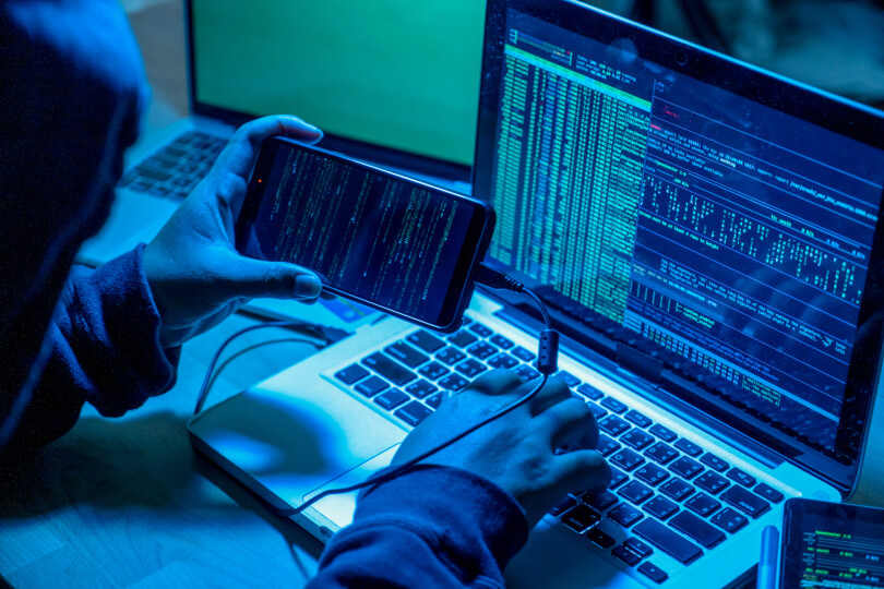 Hacker-with-computers-in-dark-room.-Cyber-crime_Gettyimagesboonchai-wedmakawand
