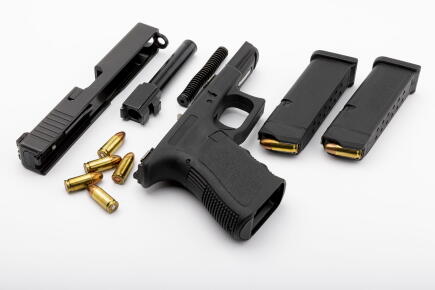 Pieces-darme-de-poing-pistolet-automatique-avec-chargeur-sur-fond-blanc-isole_GettyimagesArthit-Pornpikanet