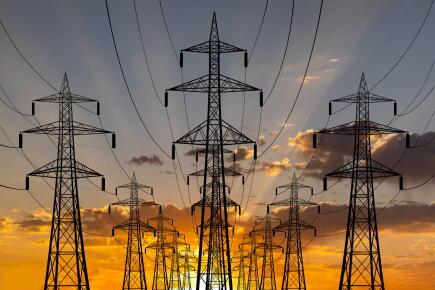 High-voltage-towers-at-sunset-background.-Power-lines-against-the-sky_GettyimagesAnton-Petrus