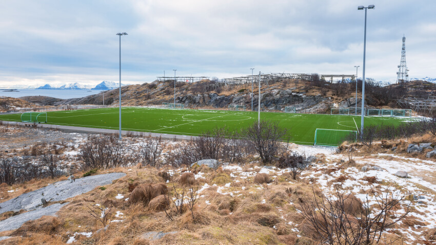 Terrain-de-football-sur-Lofoten-iles-entourees-de-roches-de-pierres-et-deau-Henningsvaer-Norvege_GettyimagesLara_Uhryn