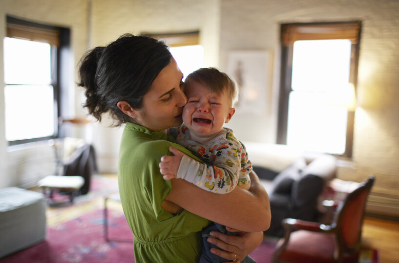 Mother-holding-and-kissing-crying-baby-boy_GettyimagesBen-Bloom