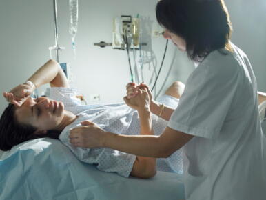 Midwife-supporting-woman-during-pregnancy-in-hospital_GettyimagesHans-Neleman