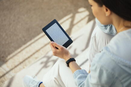 Woman-reading-an-e-book-while-sitting-on-steps_GettyimagesWestend61
