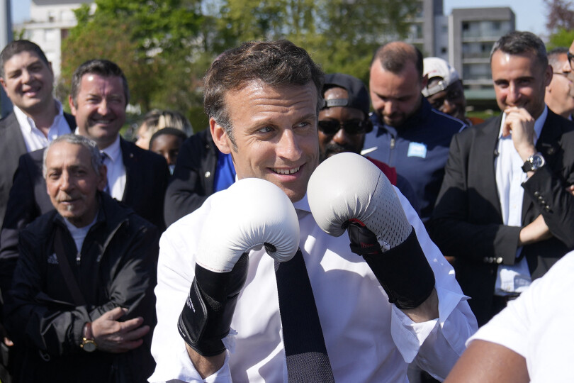 French President and La Republique en Marche (LREM) party candidate for re-election Emmanuel Macron wears boxing gloves as he meets a local boxer at the Auguste Delaune stadium on April 21, 2022 during a campaign visit in Saint-Denis, outside Paris. - French voters head to the polls on April 24, 2022 for the second round of France's presidential election. (Photo by Francois Mori / POOL / AFP)