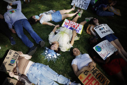 WASHINGTON, DC - APRIL 22: Young climate activists stage a "die-in" in Lafayette Park across from the White House on Earth Day on April 22, 2022 in Washington, DC. Organized by Fridays for Future DC, about 50 young people gathered to protest against the use of fossil fuels. Chip Somodevilla/Getty Images/AFP (Photo by CHIP SOMODEVILLA / GETTY IMAGES NORTH AMERICA / Getty Images via AFP)