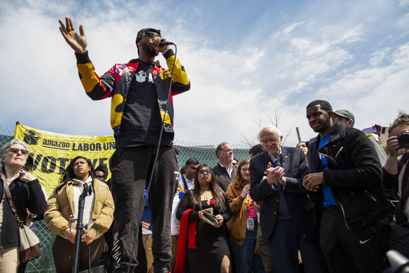 Amazon Labor Union leader Christian Smalls speaks next to US Senator Bernie Sanders (I-VT) during a rally outside the company building in Staten Island, New York City, on April 24, 2022. - A recent push for worker unionization has gained traction and found some major successes in the United States. (Photo by Kena Betancur / AFP)