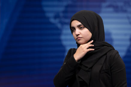 A female presenter for TOLOnews, Thamina Usmani, watches after a live broadcast at Tolo TV station in Kabul on May 22, 2022. - Women presenters on Afghanistan's leading news channels went on air on May 22 with their faces covered, a day after defying a Taliban order to conceal their appearance on television. (Photo by Wakil KOHSAR / AFP)