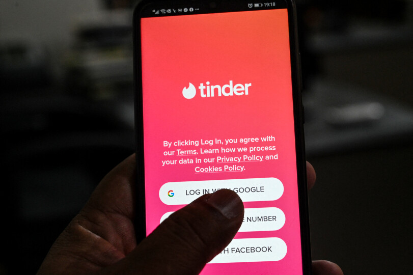 In this photo illustration taken on October 6, 2020, a user checks the dating app Tinder on a mobile phone in Islamabad. - Unlike in many countries where meeting online is routine, Pakistanis who use dating apps regularly face harassment and judgmental relatives -- and now also have to contend with a government clampdown. (Photo by Aamir QURESHI / AFP) / To go with 'PAKISTAN-MARRIAGE-DATING', FOCUS by David Stout and Kaneez Fatima in Lahore