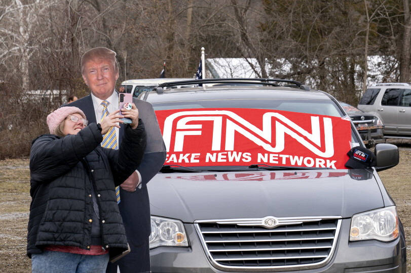 A supporter with the Peoples Convoy takes a photo with a cutout of former President Donald Trump at the Hagerstown Speedway in Hagerstown, Maryland, on March 5, 2022. According to organizers, the convoy will hold an all-day rally in Hagerstown before continuing to Washington, DC. - Hundreds of truckers and their supporters in the convoy set off from southern California to Washington to protest against Covid-19 pandemic restrictions. (Photo by Stefani Reynolds / AFP)