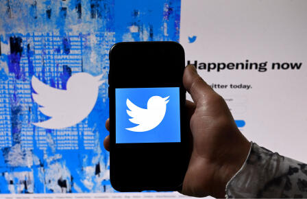(FILES) In this illustration file photo taken on April 26, 2022 a phone screen displays the Twitter logo on a Twitter page background, in Washington, DC. - Twitter agreed to pay $150 million to settle allegations the platform gave advertisers some user information that was supposed to be employed to strengthen account security, US authorities said Wednesday. (Photo by Olivier DOULIERY / AFP)