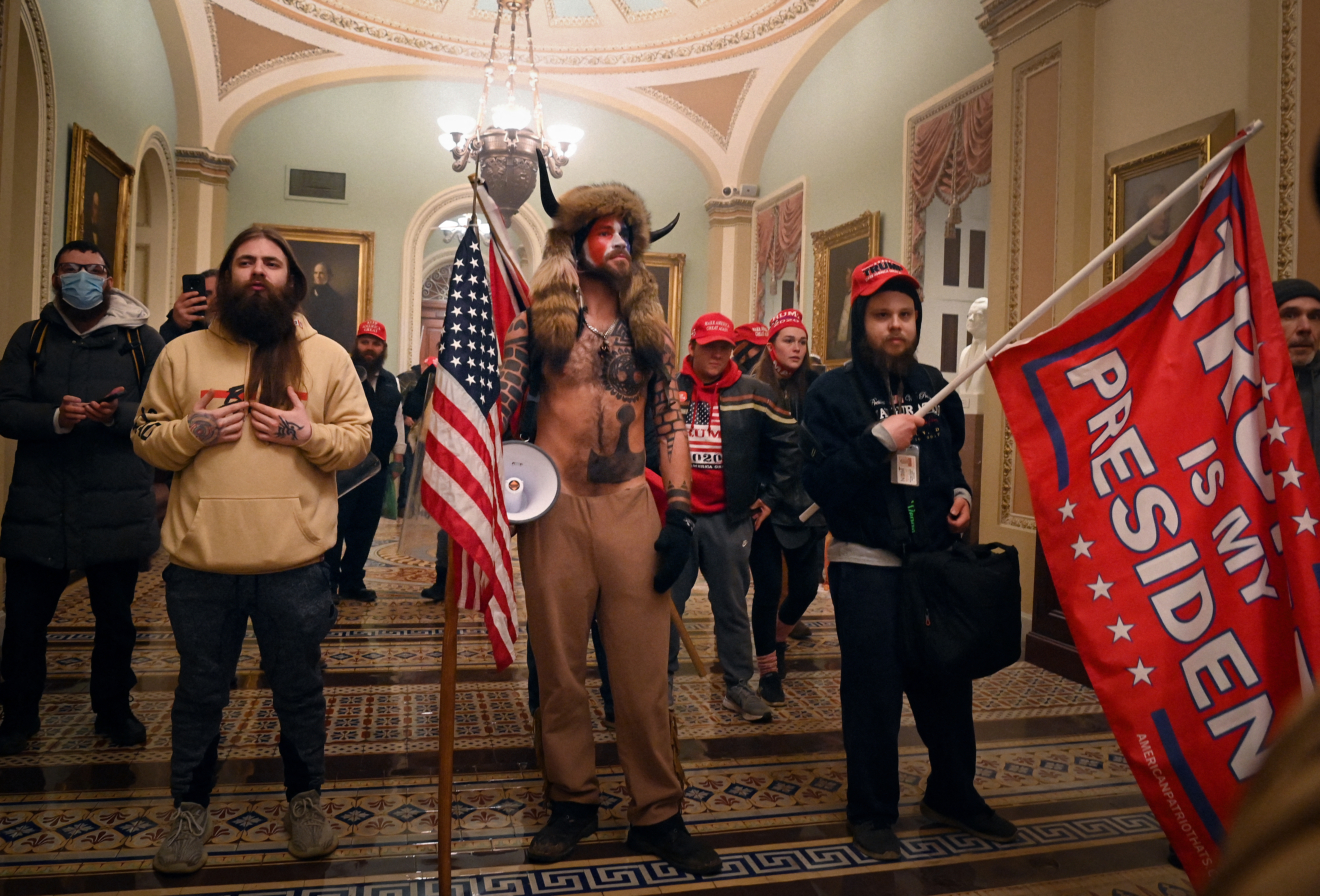Supporters of US President Donald Trump, including member of the QAnon conspiracy group Jake Angeli, aka Yellowstone Wolf (C), enter the US Capitol on January 6, 2021, in Washington, DC. - Demonstrators breeched security and entered the Capitol as Congress debated the a 2020 presidential election Electoral Vote Certification. (Photo by Saul LOEB / AFP)